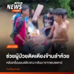 กลุ่มชาวบ้านช่วยกันหามผู้ป่วยติดเตียงออกจากรถที่ติดอยู่กลางล